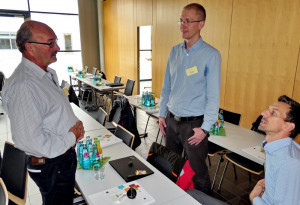 Wolfgang Härtel (l.), Jan Fröhlich (m.) und Johannes Hörber (r.) diskutieren über die MID-Demonstratoren und deren Anwendung