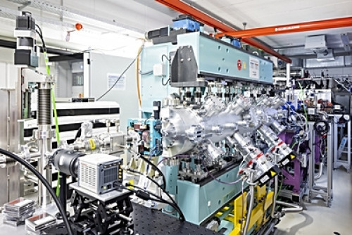 Der Freie-Elektronen-Laser (FEL) der französischen Forschungspartner wandelt die vom Hochleistungslaser DRACO am HZDR erzeugten Elektronenpulse in Lichtblitze um. Im Vordergrund das von einer hellblauen Magnetanordnung - dem Undulator - eingerahmte Strahlrohr, im Hintergrund die metallische Strahlkammer für den DRACO-Laser (Bild: HZDR/Sylvio Dittrich)