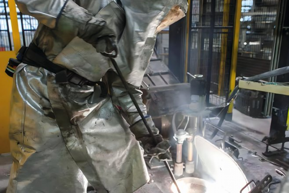 A smelter in a large German magnesium die-casting foundry cleans a magnesium smelting unit. Due to the risk of fire, cleanliness and order are the top priorities in magnesium smelting plants   